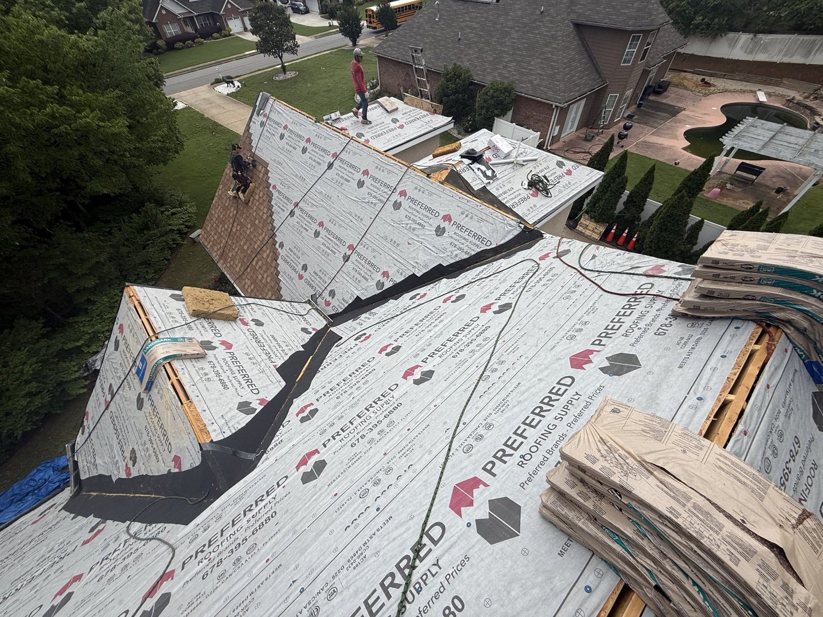 Capstone Solutions crew installing synthetic underlayment on a roof replacement in Georgia