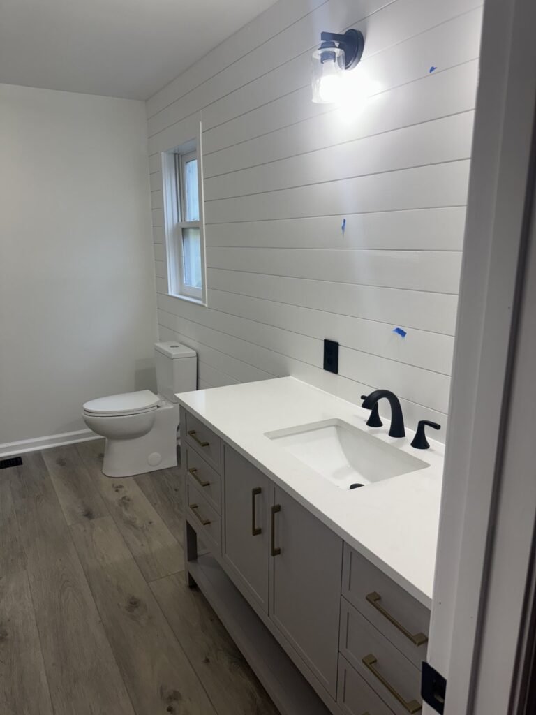 Shiplap accent wall with a new vanity and lighting