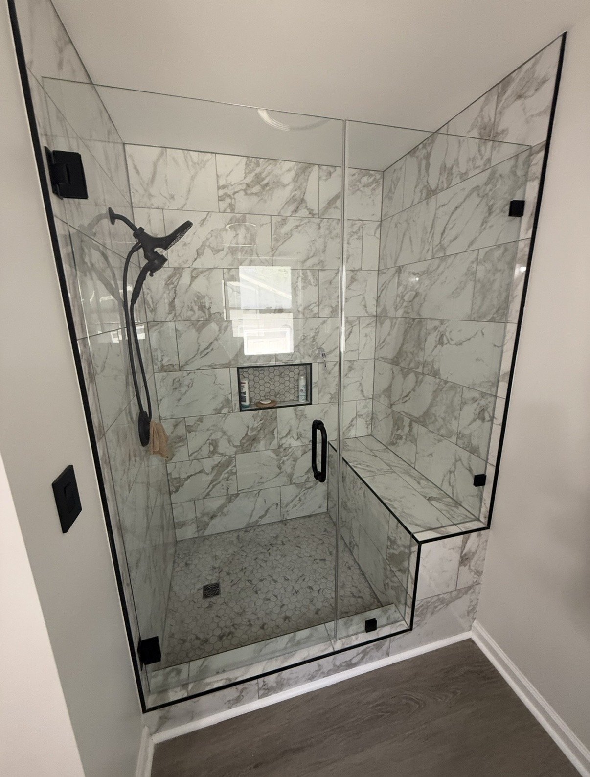 Finished marble tile shower remodel with frameless glass door by Capstone Solutions