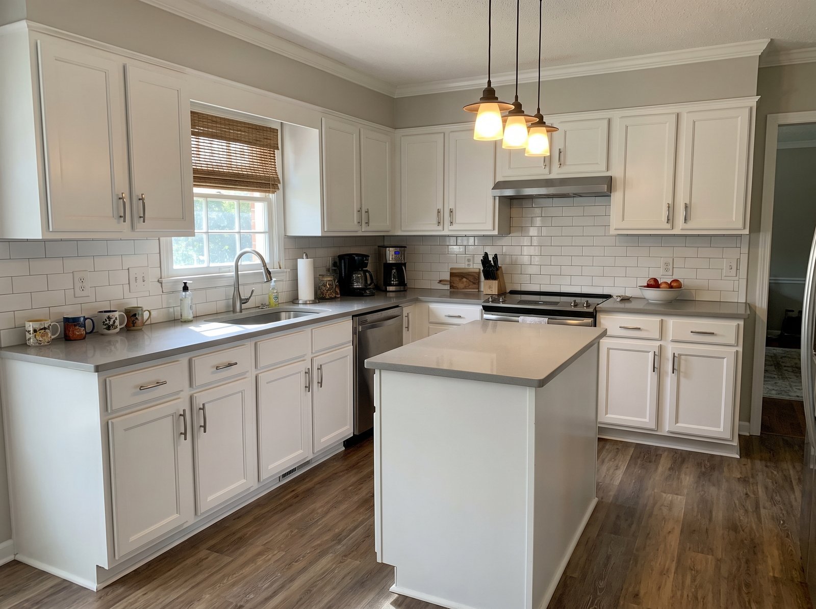 Example of a remodeled kitchen with white cabinets and a tile backsplash