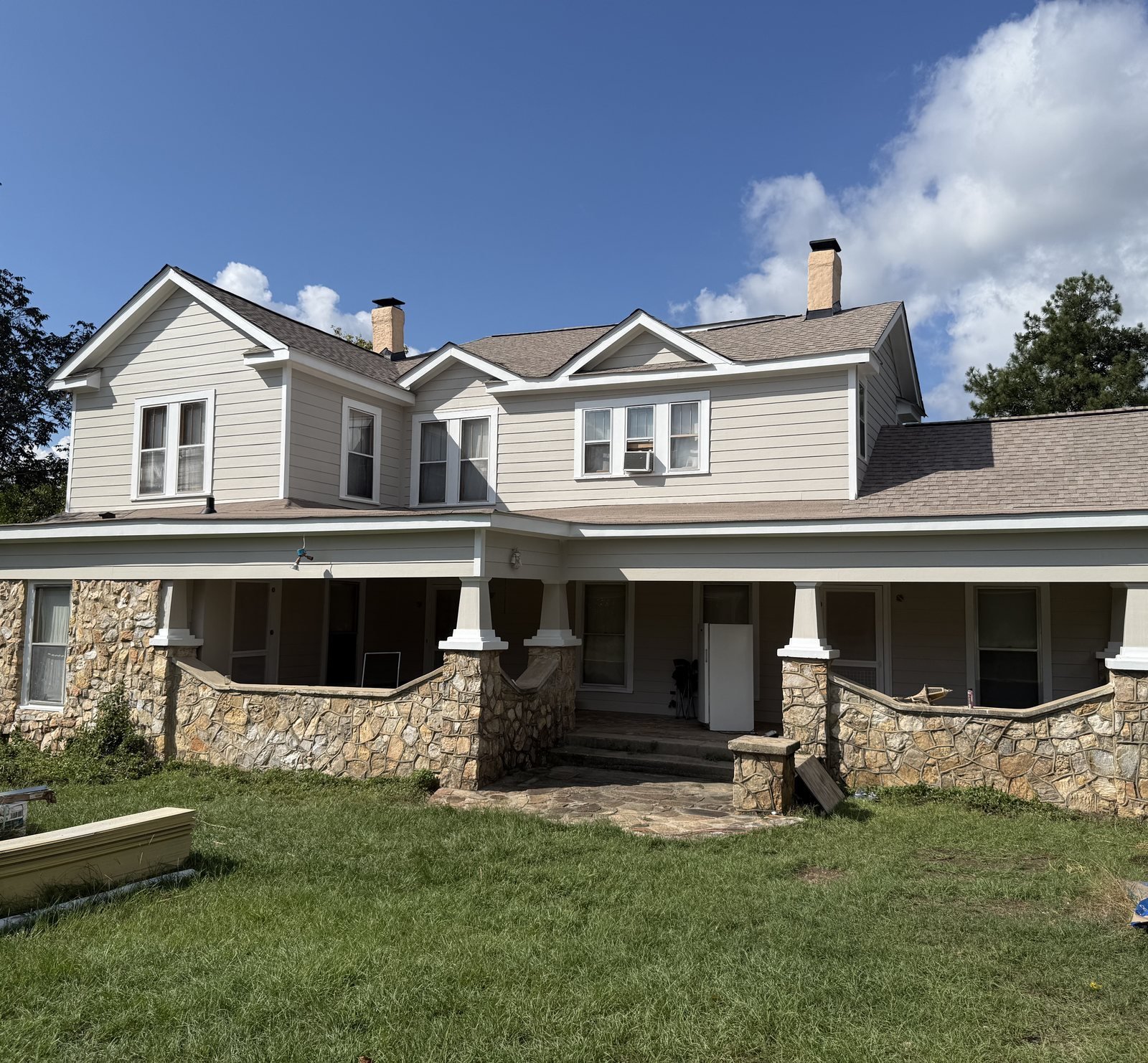 Two-story home with finished siding, stone and a covered front porch